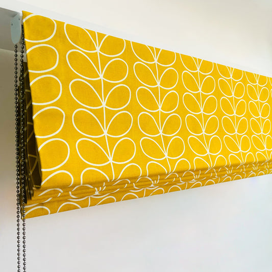 Side view of made-to-measure Roman blind in Orla Kiely Dandelion Yellow fabric, showing professional finish and deluxe chain-operated headrail.