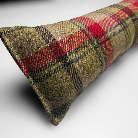 Handmade wool tartan draught excluder in green, red, and brown tones, designed to block drafts under doors.