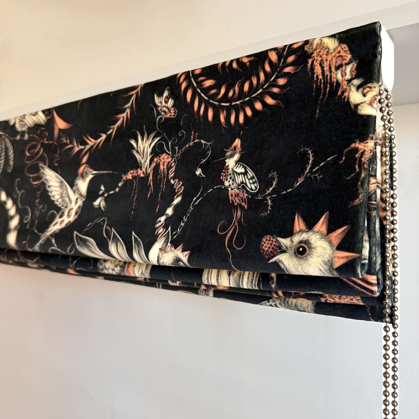 Decorative blind with bird and floral pattern on a plain background