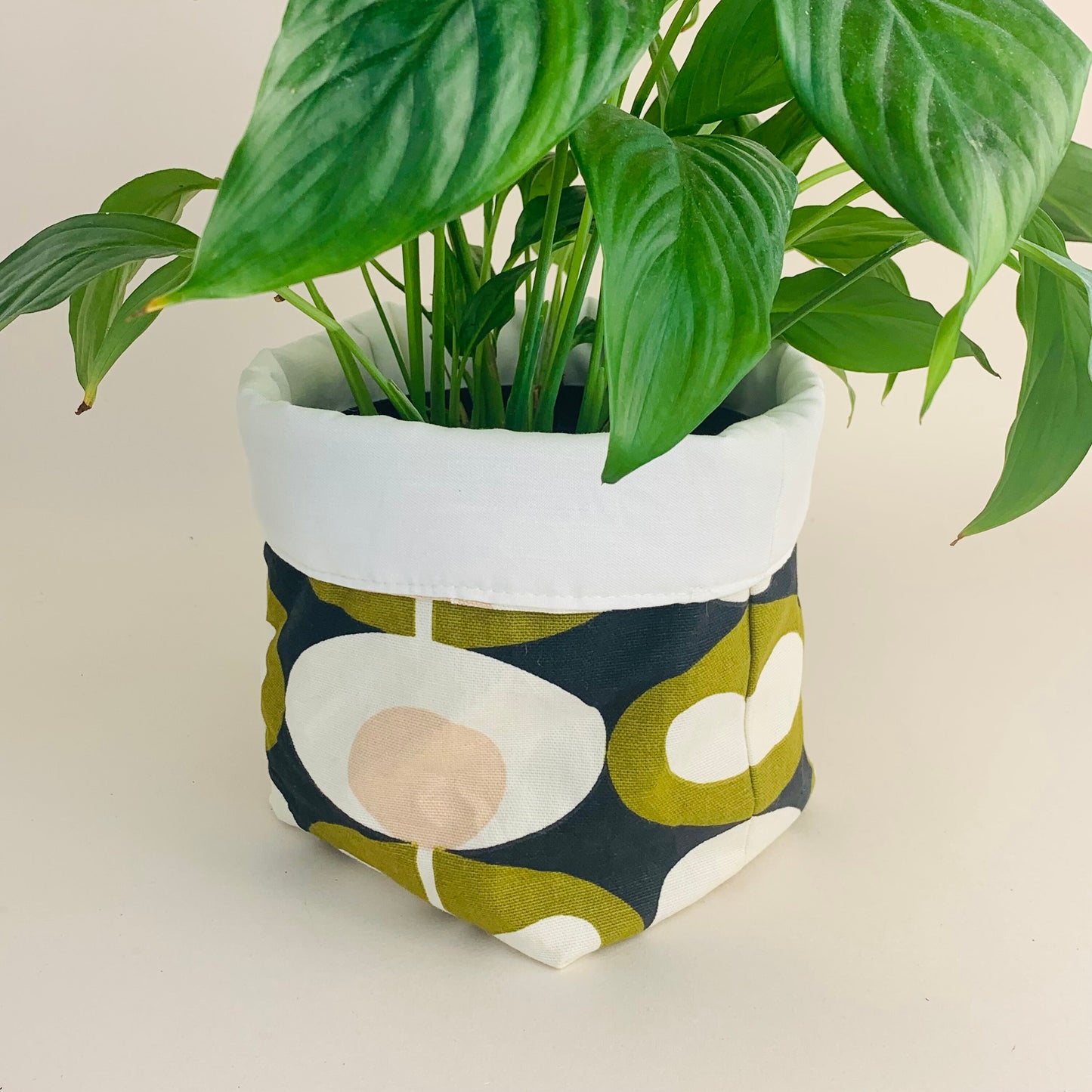 Orla Kiely fabric plant pots and storage baskets in grey and olive, lined with linen or hessian. These versatile containers feature retro-inspired patterns, perfect for adding a stylish touch to your home decor while providing practical storage solutions