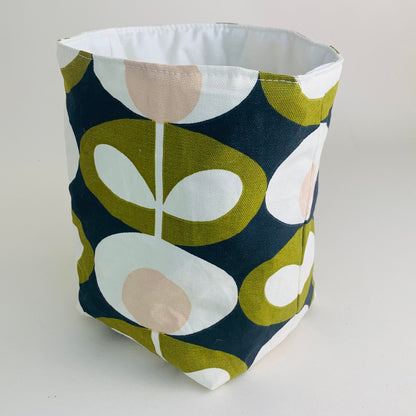 Orla Kiely fabric plant pots and storage baskets in grey and olive, lined with linen or hessian. These versatile containers feature retro-inspired patterns, perfect for adding a stylish touch to your home decor while providing practical storage solutions